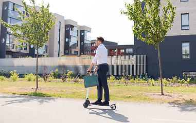 Image showing businessman with shopping bag riding scooter