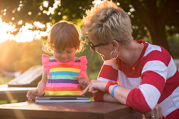 Image showing mom and her little daughter using tablet computer