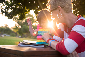 Image showing mom and her little daughter using tablet computer