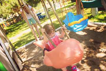 Image showing mother and daughter swinging in the park