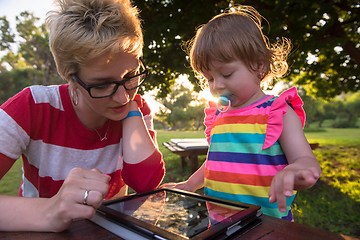 Image showing mom and her little daughter using tablet computer