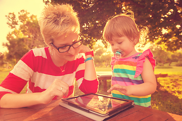 Image showing mom and her little daughter using tablet computer