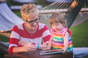 Image showing mom and her little daughter using tablet computer