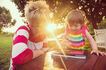 Image showing mom and her little daughter using tablet computer