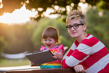 Image showing mom and her little daughter using tablet computer