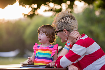 Image showing mom and her little daughter using tablet computer