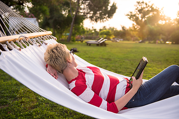 Image showing woman using a tablet computer while relaxing on hammock