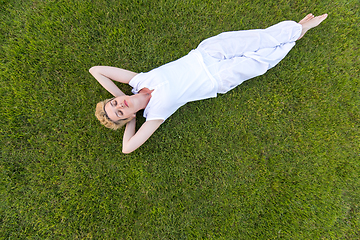 Image showing top view of young woman relaxing on the grass