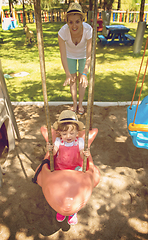 Image showing mother and daughter swinging in the park