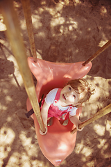 Image showing little girl swinging  on a playground