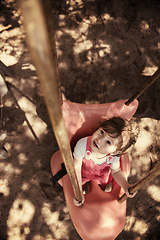 Image showing little girl swinging  on a playground