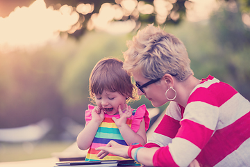 Image showing mom and her little daughter using tablet computer