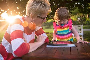 Image showing mom and her little daughter using tablet computer