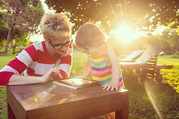 Image showing mom and her little daughter using tablet computer