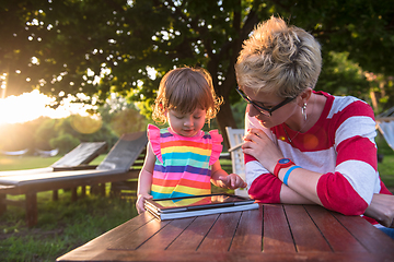 Image showing mom and her little daughter using tablet computer