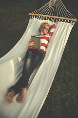 Image showing woman using a tablet computer while relaxing on hammock