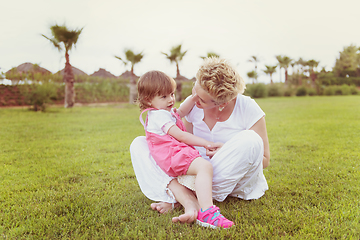 Image showing mother and little daughter playing at backyard