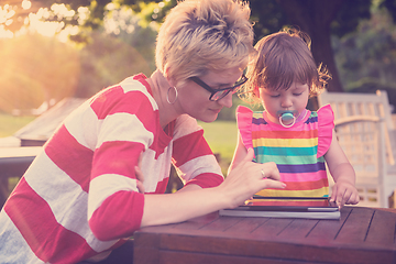 Image showing mom and her little daughter using tablet computer