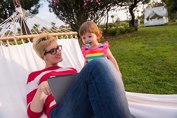 Image showing mom and a little daughter relaxing in a hammock