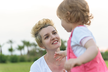 Image showing mother and little daughter playing at backyard