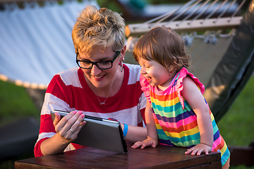 Image showing mom and her little daughter using tablet computer