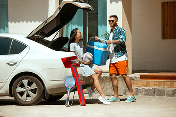 Image showing Young couple preparing for vacation trip on the car in sunny day
