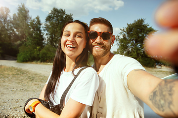 Image showing Young couple making selfie near by car in sunny day