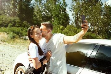 Image showing Young couple making selfie near by car in sunny day