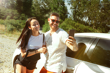 Image showing Young couple making selfie near by car in sunny day