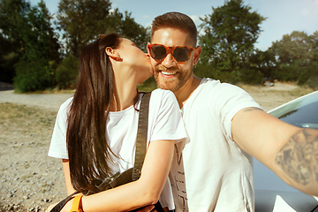 Image showing Young couple making selfie near by car in sunny day