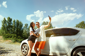 Image showing Young couple making selfie near by car in sunny day