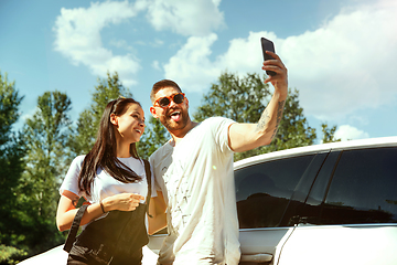 Image showing Young couple making selfie near by car in sunny day