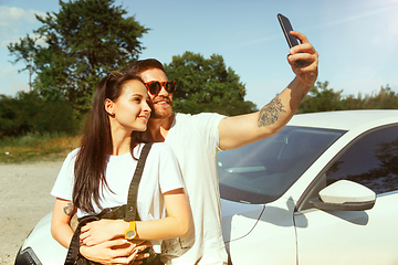 Image showing Young couple making selfie near by car in sunny day