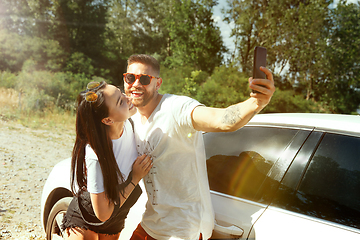 Image showing Young couple making selfie near by car in sunny day