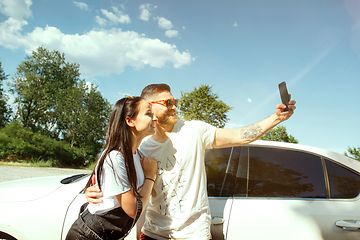 Image showing Young couple making selfie near by car in sunny day