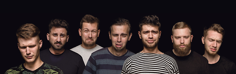 Image showing Close up portrait of young men isolated on black studio background