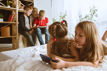 Image showing Little boys and girls using different gadgets at home