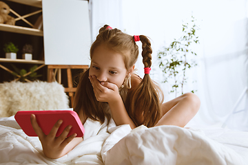 Image showing Little girl using different gadgets at home