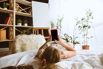 Image showing Little girl using different gadgets at home