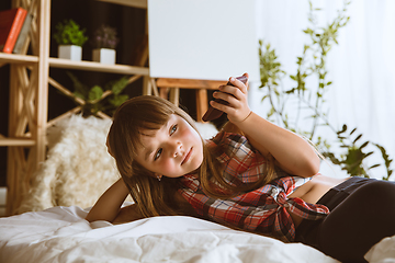 Image showing Little girl using different gadgets at home