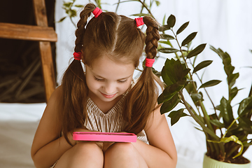 Image showing Little girl using different gadgets at home