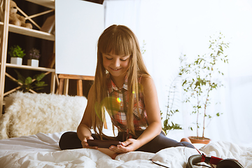 Image showing Little girl using different gadgets at home