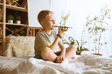 Image showing Little boy using different gadgets at home