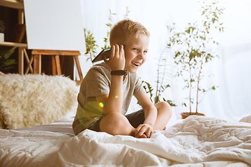 Image showing Little boy using different gadgets at home