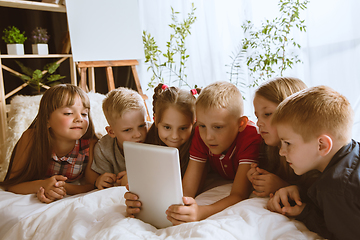 Image showing Little boys and girls using different gadgets at home