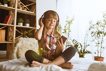 Image showing Little girl using different gadgets at home