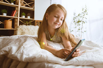 Image showing Little girl using different gadgets at home