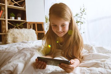 Image showing Little girl using different gadgets at home