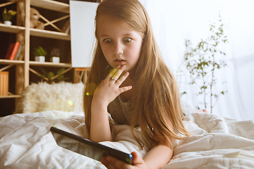 Image showing Little girl using different gadgets at home