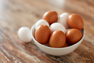 Image showing close up of eggs in ceramic bowl on wooden table